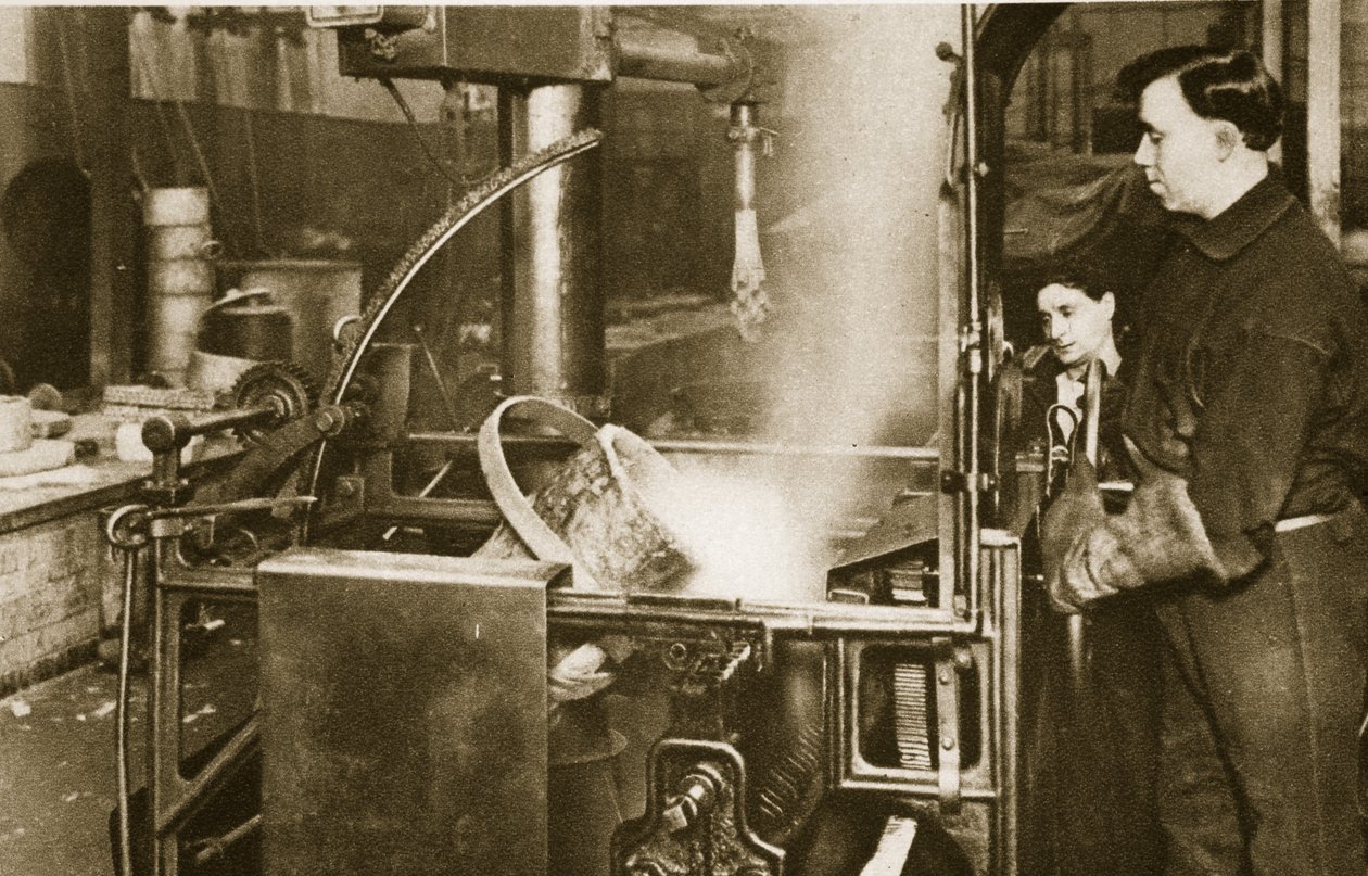 Fabricando dinero: bajando una olla de metal líquido en una máquina de English Photographer