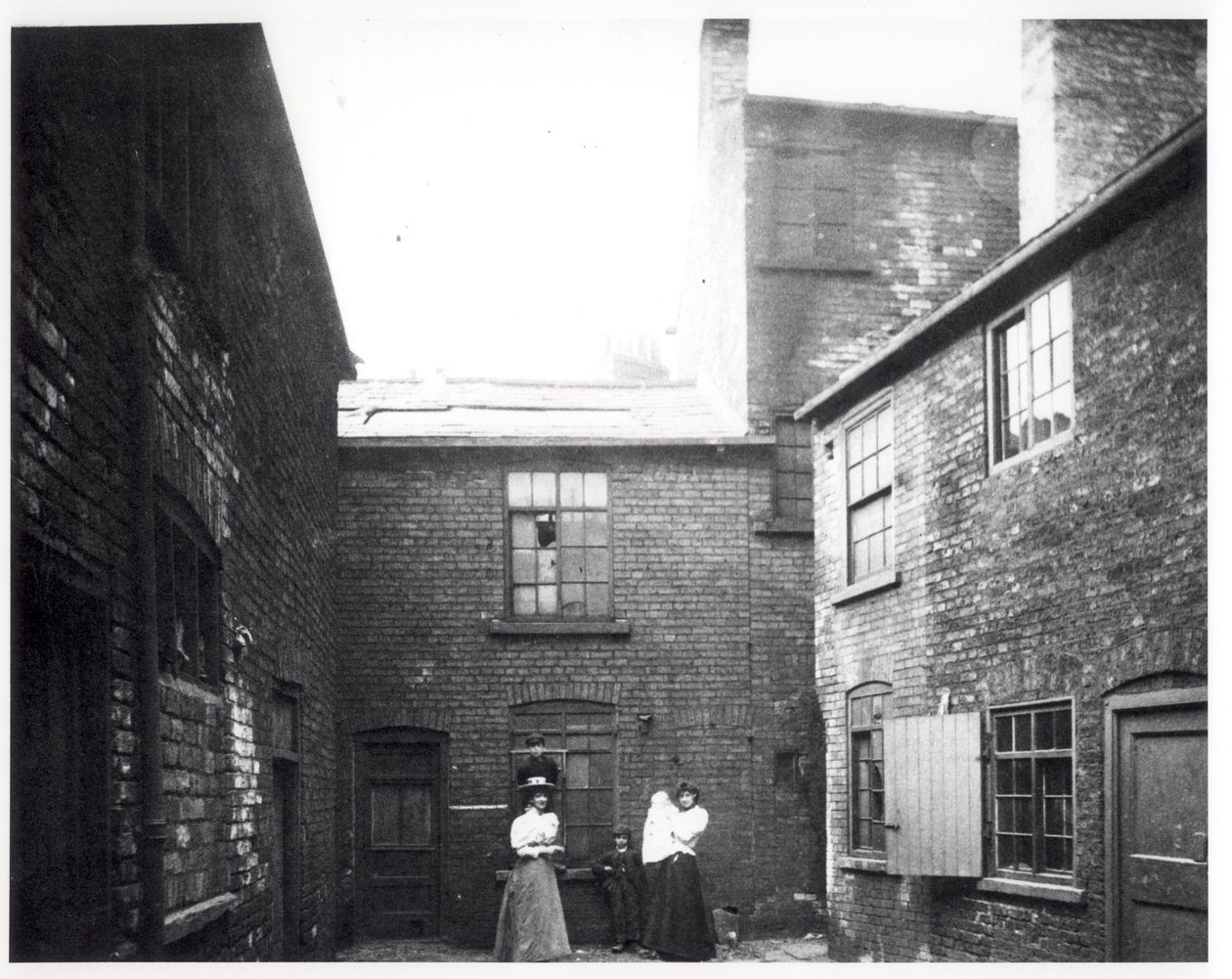 Dos mujeres posan con sus hijos, Eagle and Child Yard, Hunslet, Leeds, 13 de mayo de 1896 de English Photographer
