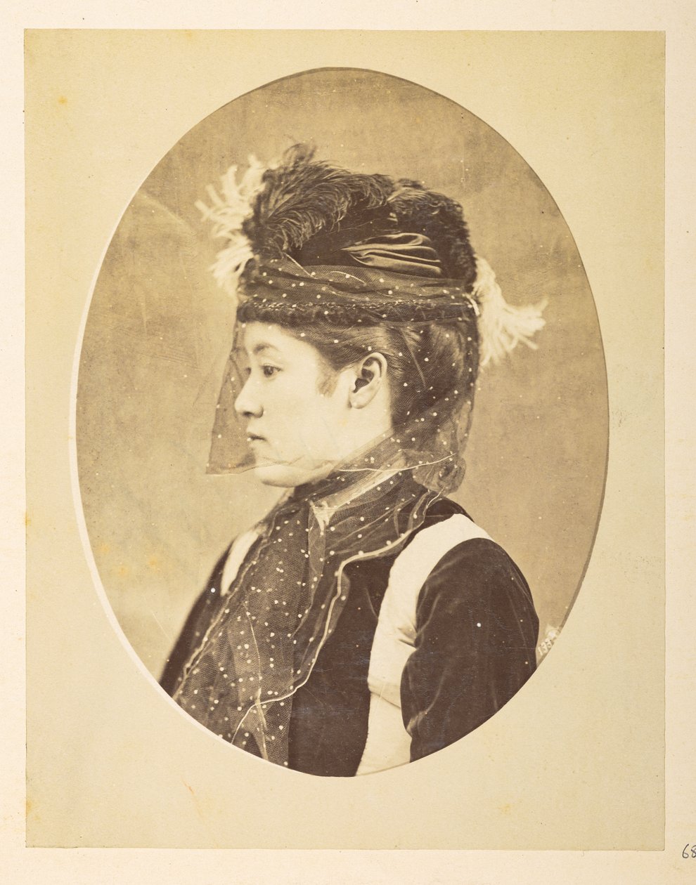 mujer japonesa en vestido europeo, imagen ovalada; retrato de perfil izquierdo de cabeza y hombros de una joven japonesa vestida de europeo, con sombrero y velo,     Fotógrafo: Desconocido  Colección Lucas: Registro fotográfico de la gira mundial de Charle de English Photographer