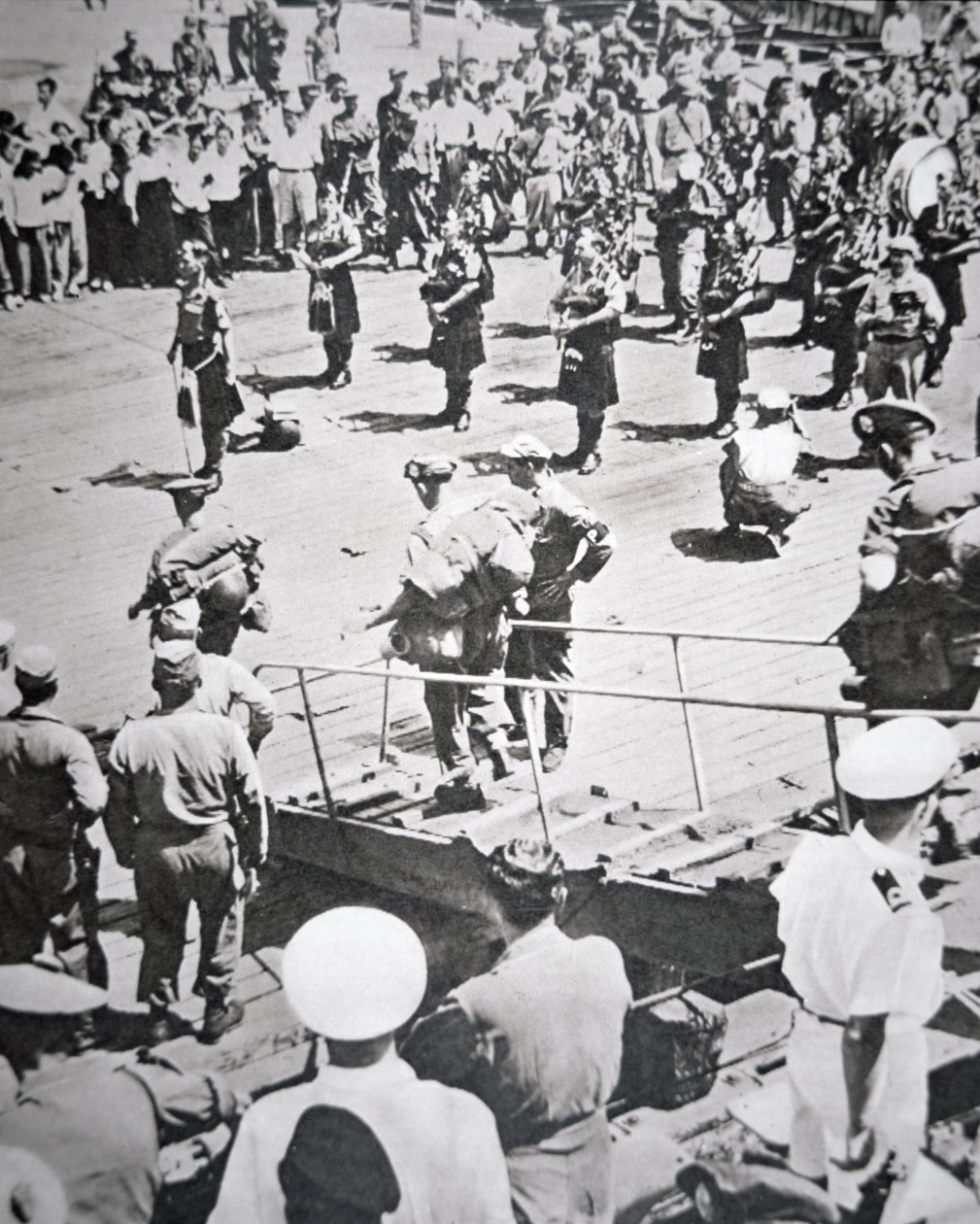 Gaiteros con falda escocesa desembarcan del 1er Batallón Argyll y Sutherland Highlanders del HMS Ceylon en Pusan, 29 de agosto de 1950 de English Photographer