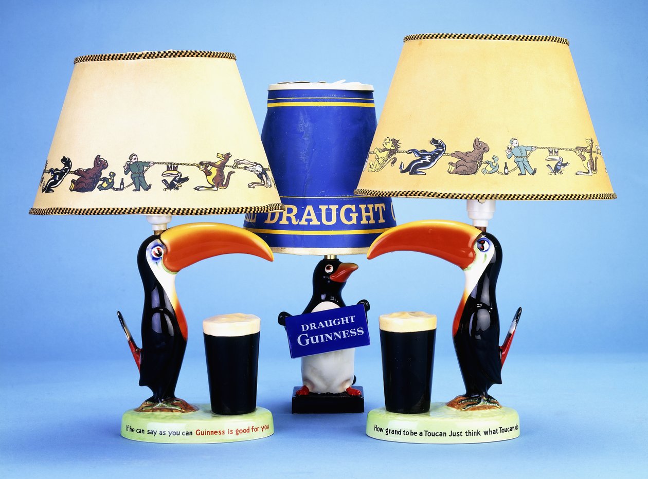 Una base de lámpara modelada como un tucán junto a un vaso de pinta de English School