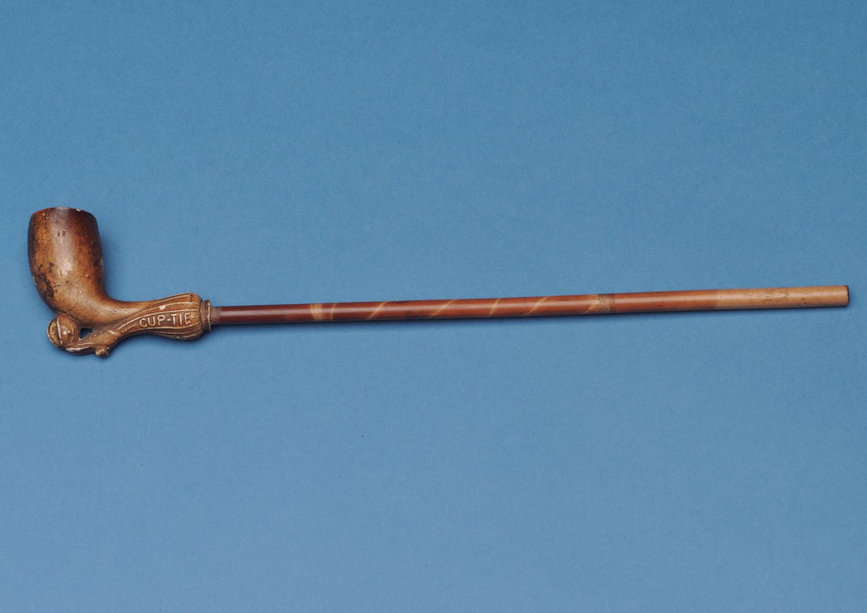 Pipa de copa con tallo de bambú y bota tallada pateando un balón debajo de English School