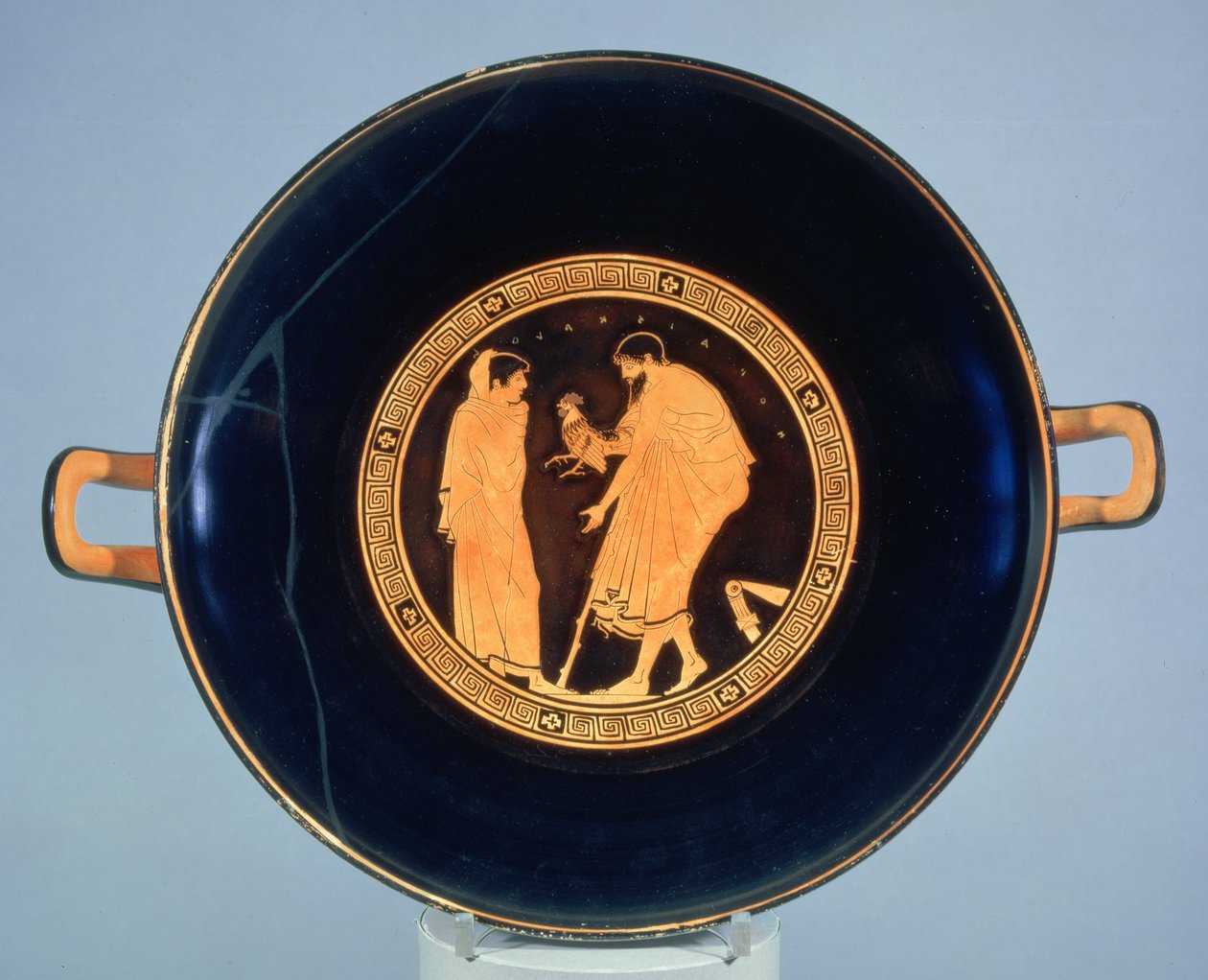 Copa de figuras rojas áticas decorada con un hombre dando un gallo a un niño, c.470 a.C. (cerámica) de Euaichme Painter