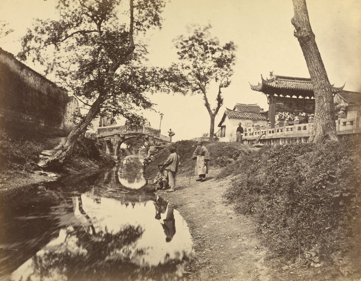 [Vista china de un río y un puente en un pueblo con varios chinos]. de Felice Beato