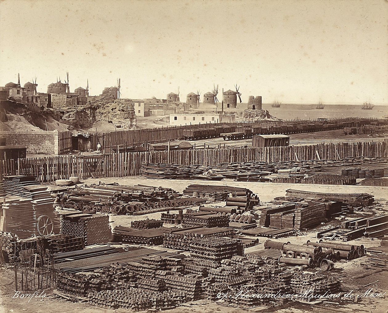 Patio para materiales de construcción, molinos de viento en el fondo, en Alejandría, Egipto de Félix Bonfils