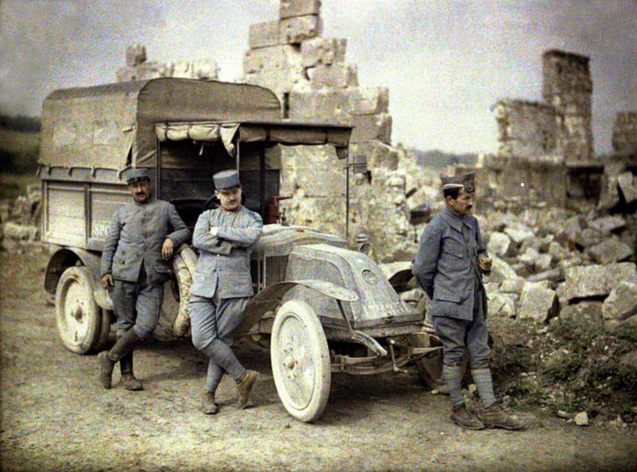 Tres soldados franceses estacionados frente a un edificio gravemente dañado con un pequeño camión, Aisne, Francia, 1917 de Fernand Cuville