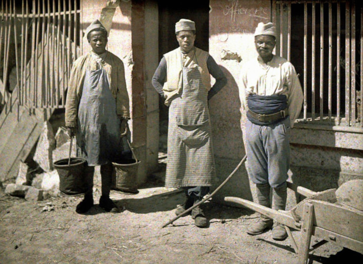 Tres trabajadores de Senegal frente a una casa, Soissons, Aisne, Francia, 1917 de Fernand Cuville