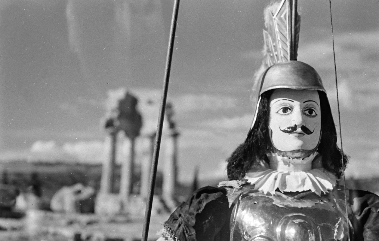 Marioneta siciliana. Al fondo, el Templo de Cástor y Pólux o de Cástor y Pólux en el Valle de los Templos de Agrigento. de Fosco Maraini