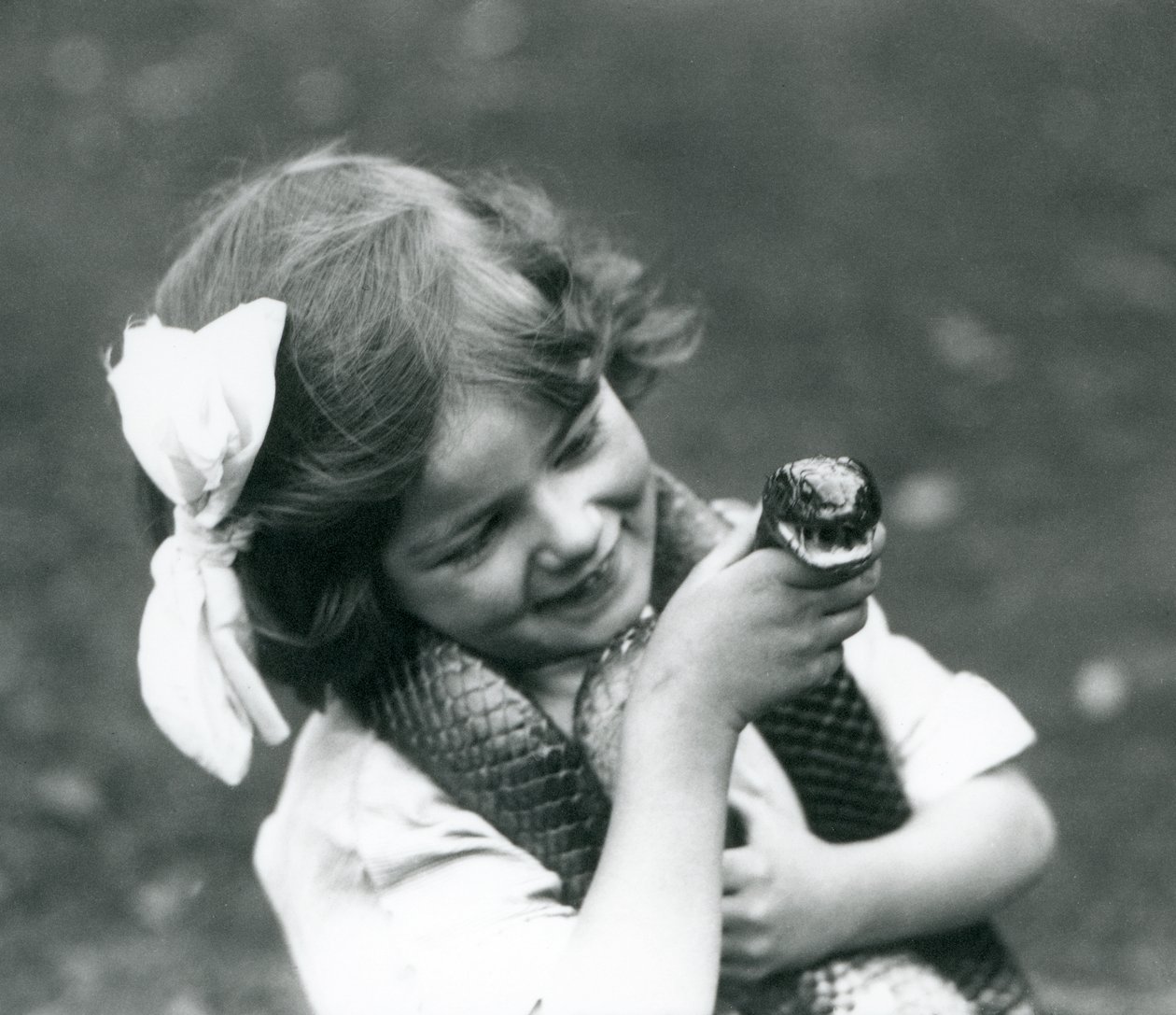 Una niña, Betty, sosteniendo una serpiente índigo oriental, Zoológico de Londres, 1924 de Frederick William Bond
