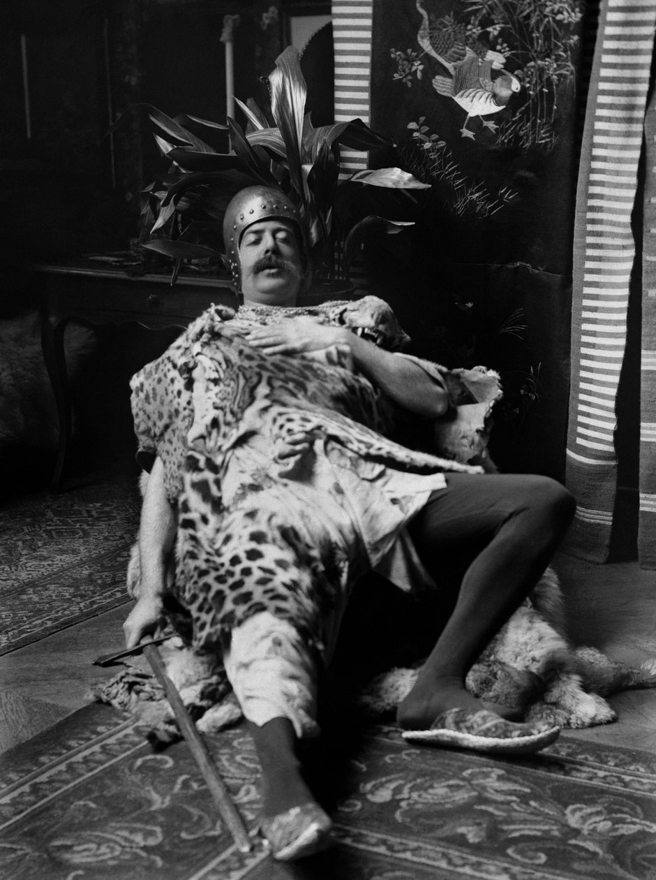 Un hombre con traje de pieles de tigre, casco y una espada en mano, teatralizando la muerte del guerrero, en la Abadía de Septfontaines, cerca de Bourmont en Haute Marne. Fotografía finales del siglo XIX. Colección Ducos de French Photographer