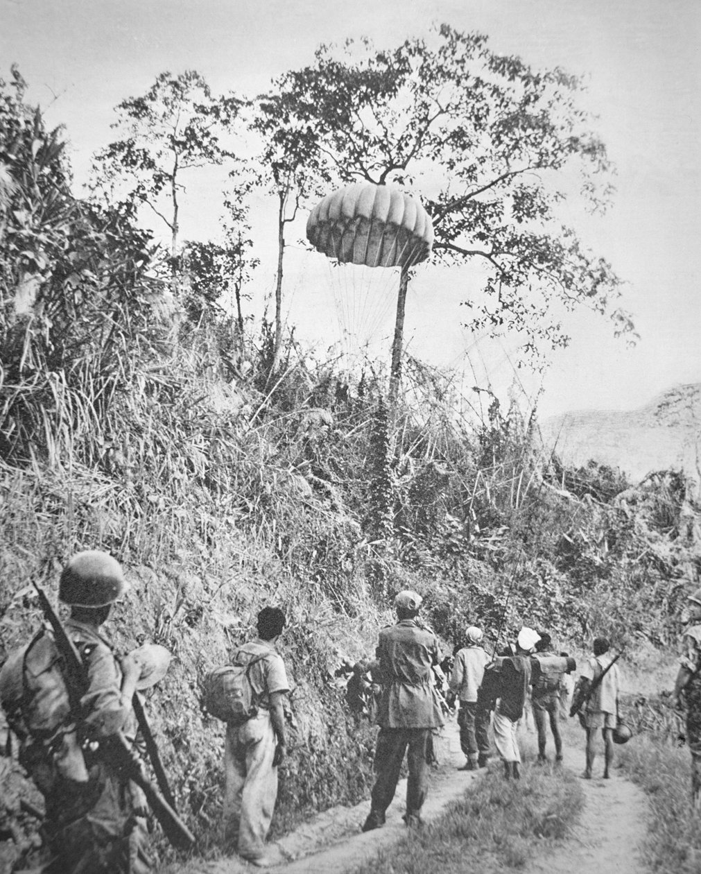 Soldados franceses y vietnamitas recuperan suministros lanzados en paracaídas durante el sitio de Dien Bien Phu, noviembre 1953-mayo 1954 de French Photographer