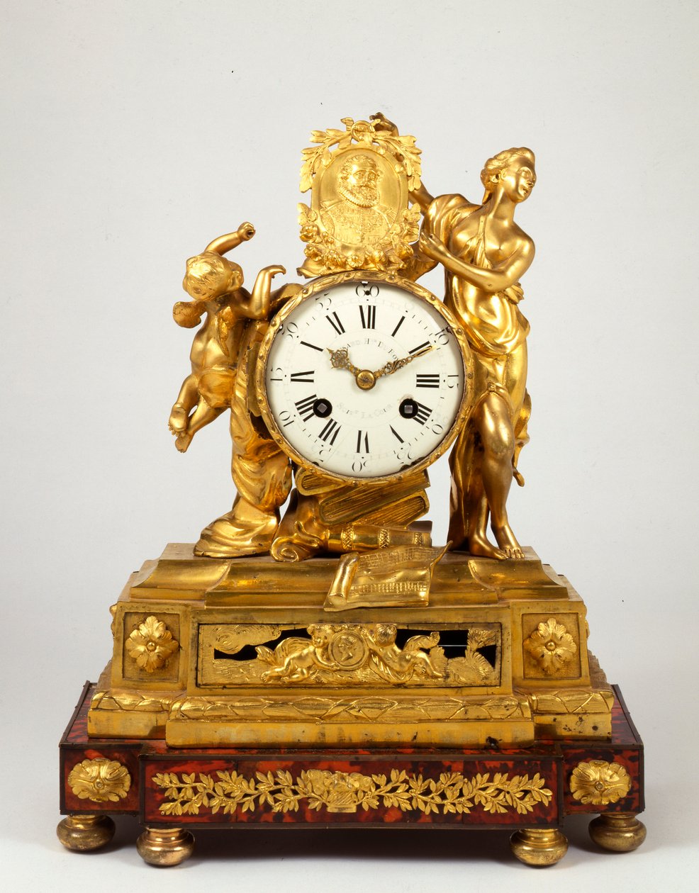 Un reloj de chimenea de bronce dorado de finales de Luis XV con un medallón de perfil de Enrique IV sostenido por Venus de French School