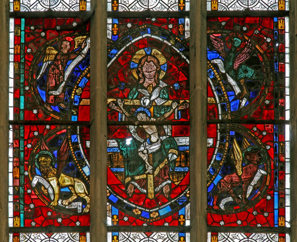 Ventana w200 que representa la Trinidad rodeada por los emblemas de los Evangelistas de French School