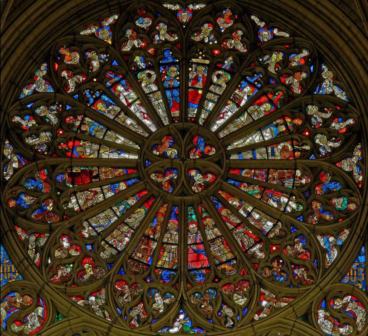 Ventana w217, la ventana norte de la rosa, que representa la Coronación de la Virgen en las dos aberturas superiores, rodeada de ángeles con instrumentos musicales y los Instrumentos de la Pasión de French School