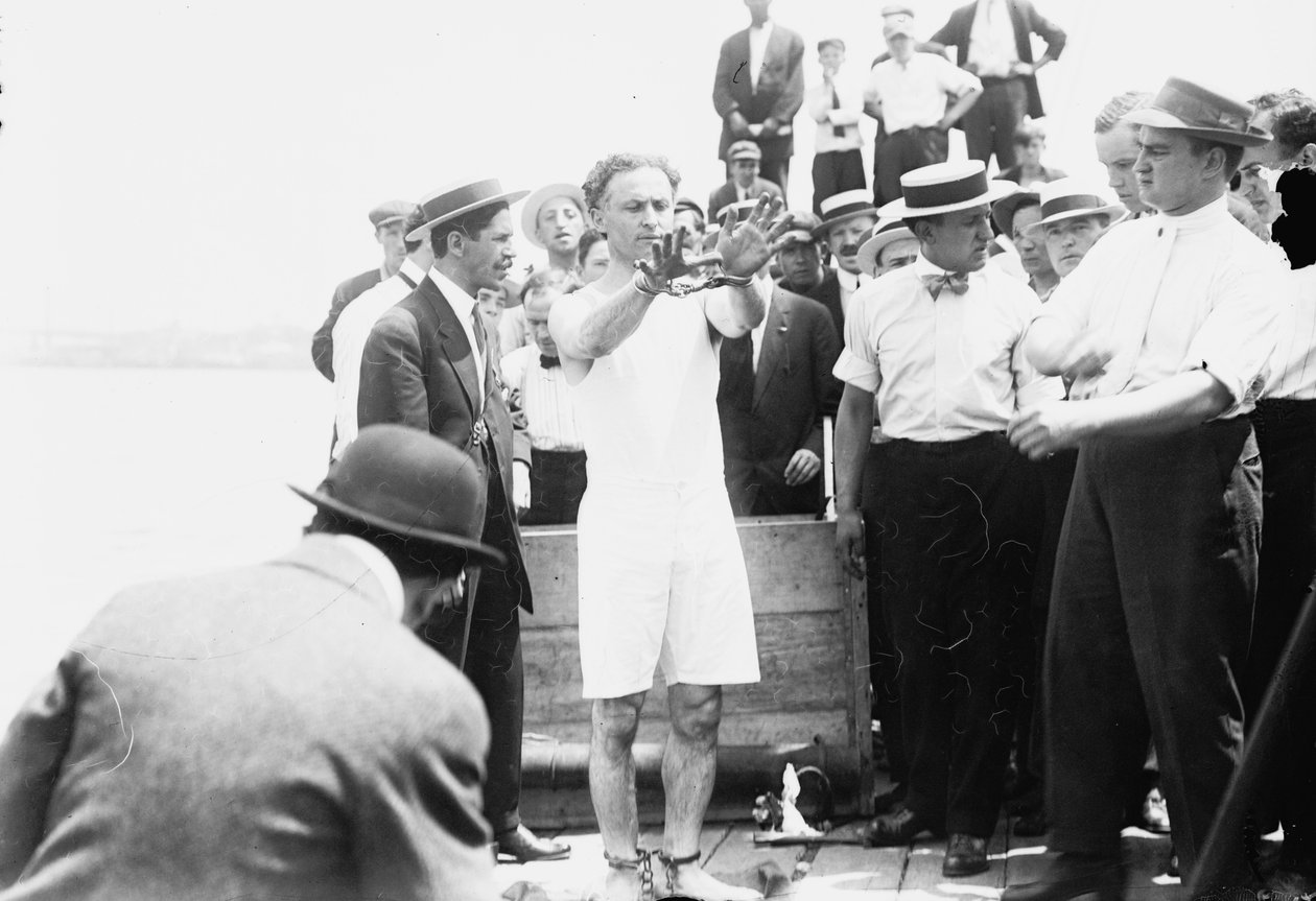 Harry Houdini siendo esposado antes de ser clavado en una caja y bajado a la bahía de Nueva York, 1912 de George Grantham Bain