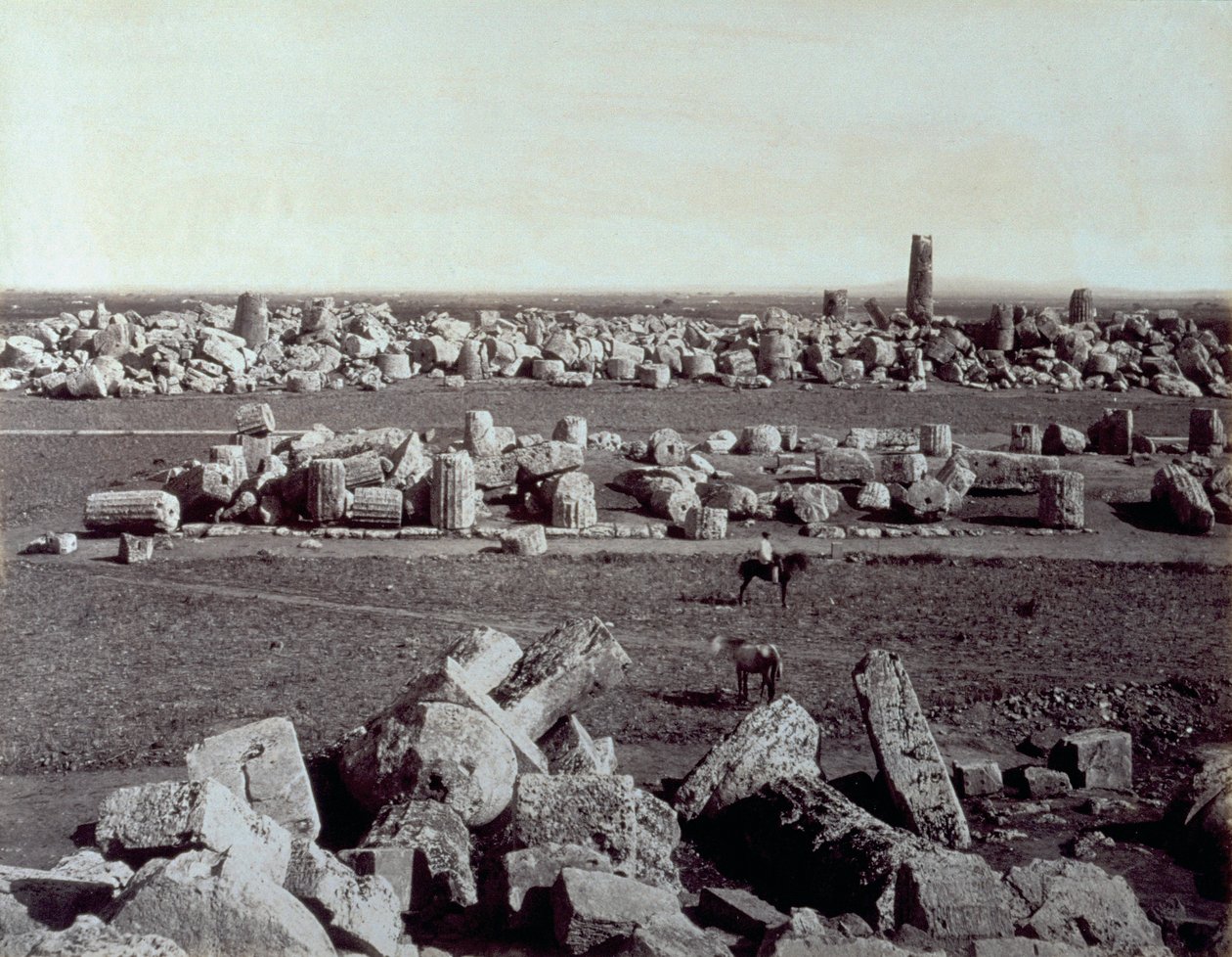 Panorama de los restos del Templo de Minerva y el Templo de Apolo en Selinunte. Hay un hombre a caballo entre las ruinas del sitio arqueológico de Giorgio Sommer