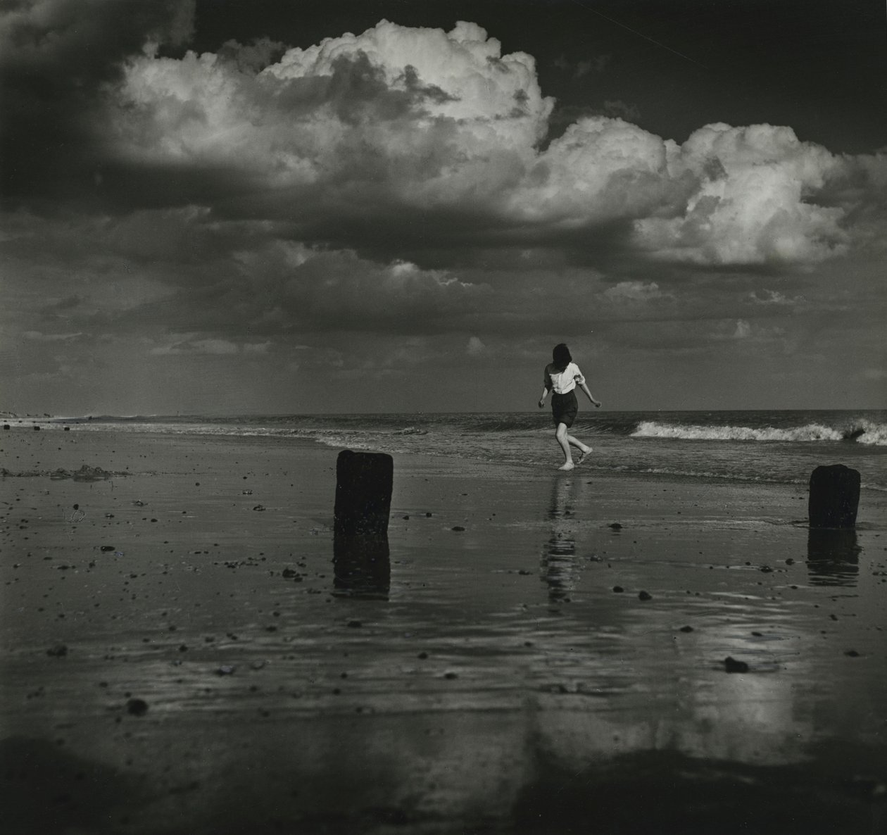 Niño jugando con las olas en la playa. de Godfrey Macdominic