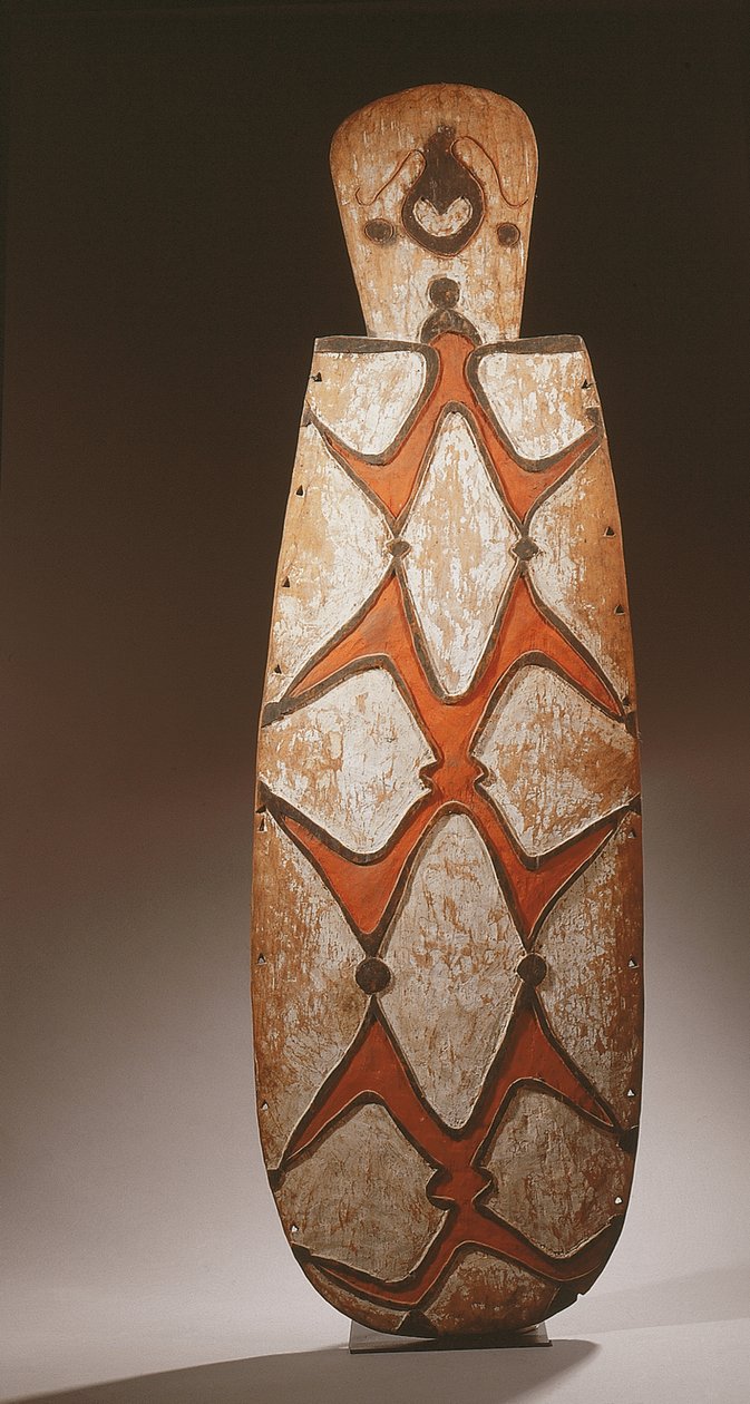 Escudo ovalado Asmat, tallado en relieve con figuras estilizadas, una máscara en la parte superior de Guinean New