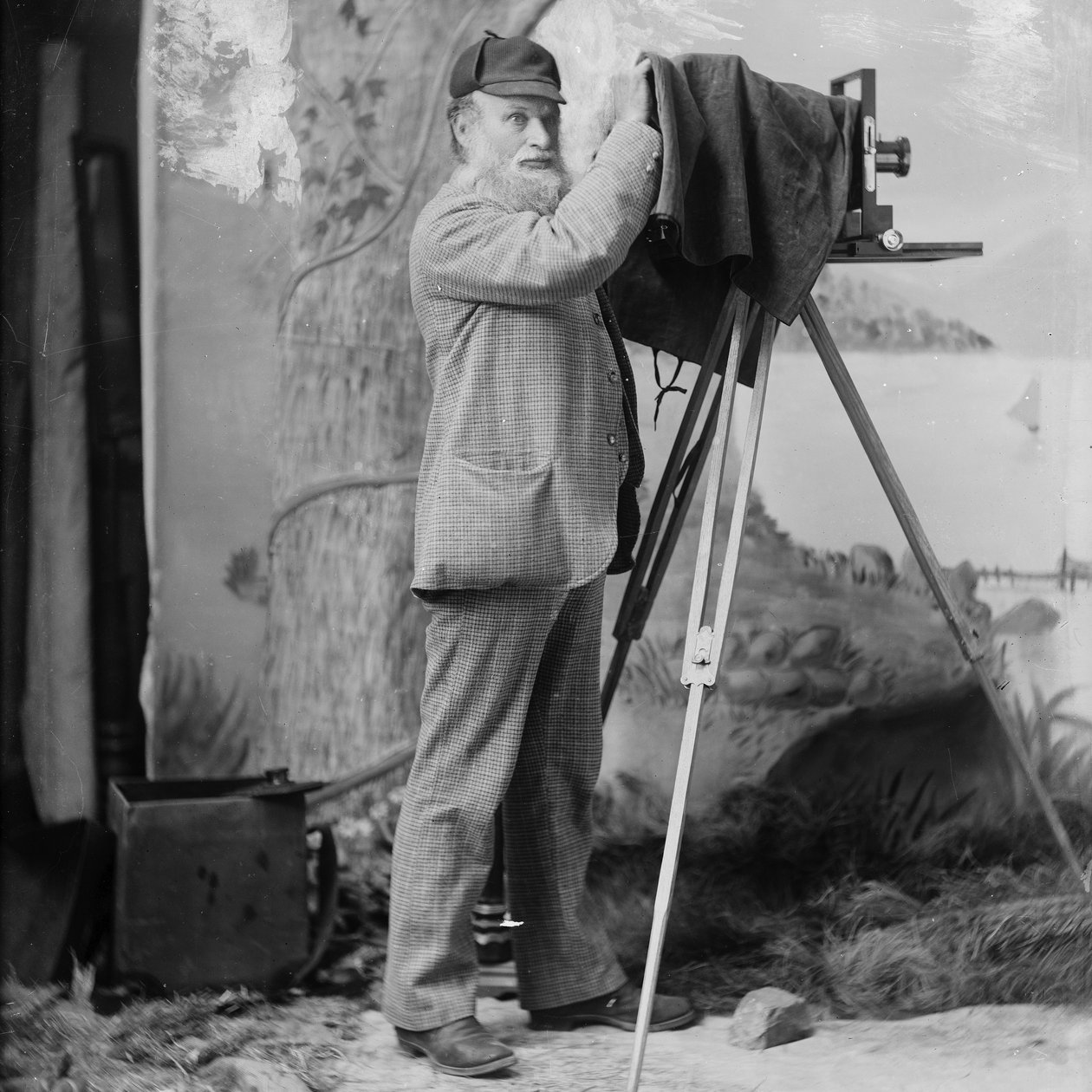 Fotógrafo Richard Maynard con cámara de campo en trípode dentro del estudio de Hannah Maynard, Victoria, BC, 1890s (foto en blanco y negro) de Hannah Maynard