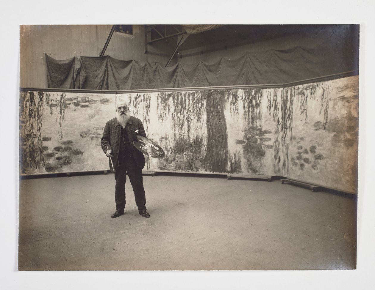 Claude Monet con su paleta delante de su obra "Les nymphéas". de Henri (attr. to) Manuel