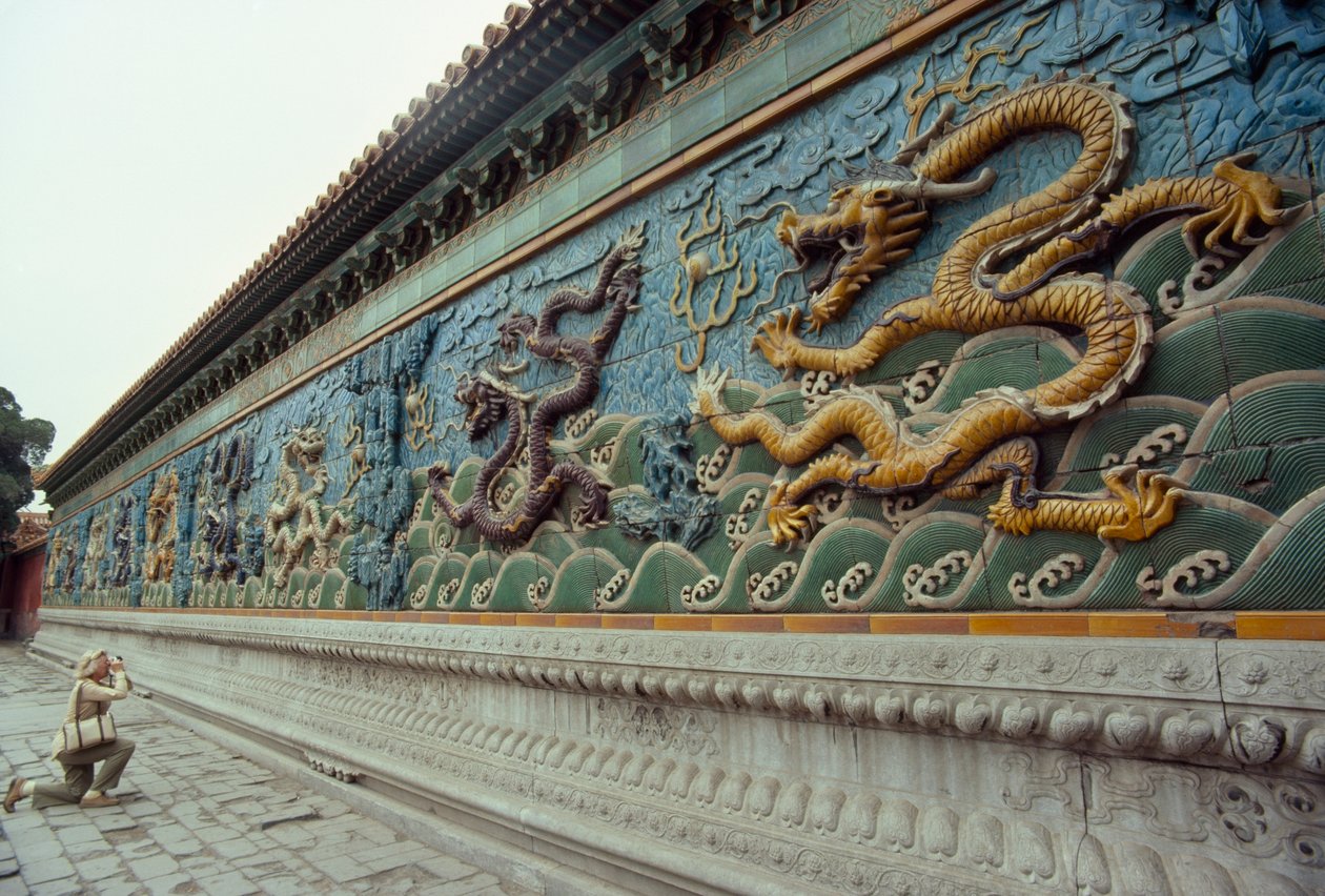 Una mujer fotografía la Pantalla de los Nueve Dragones. Parque Beihai, Pekín, República Popular China. de James L Stanfield