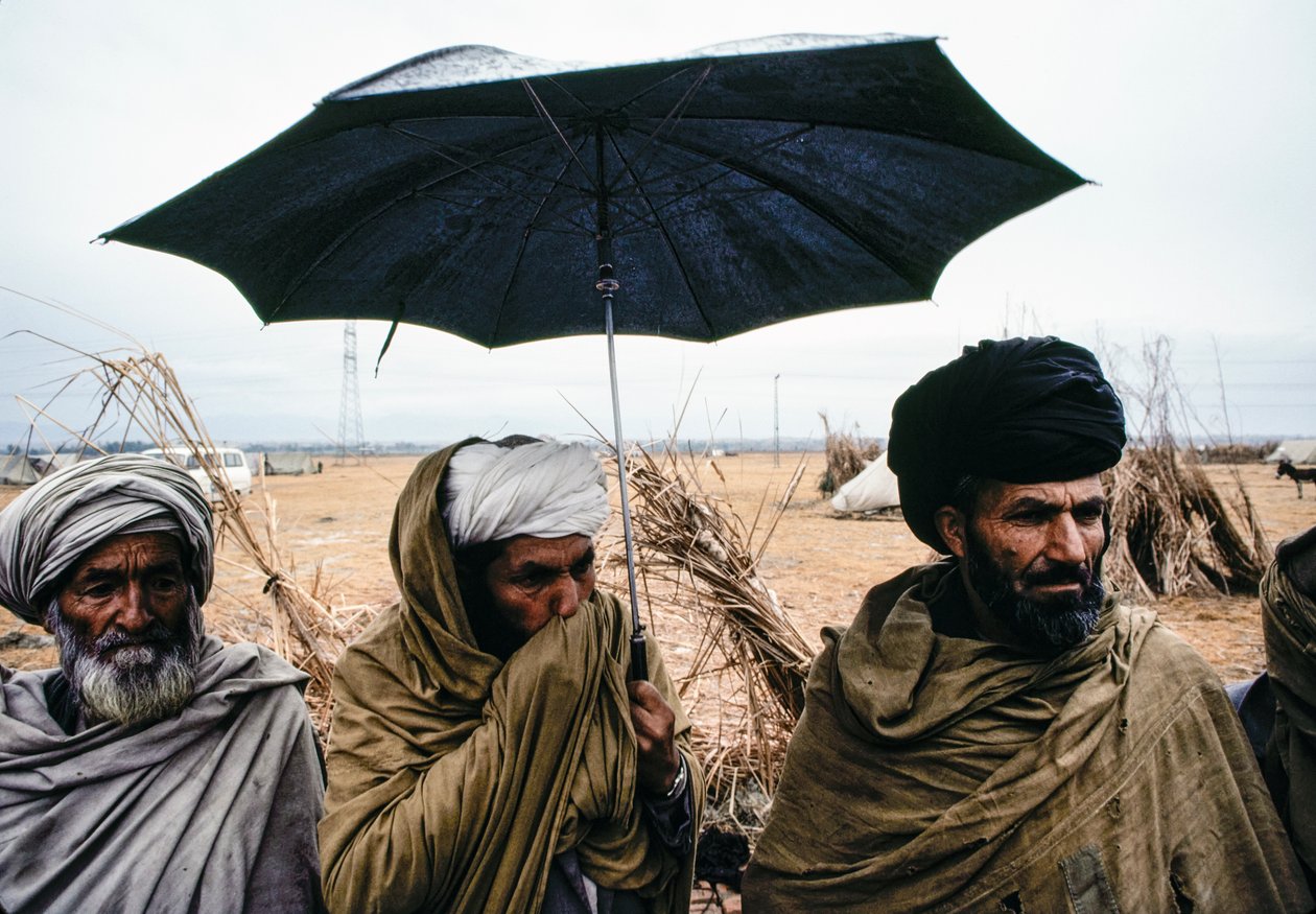 Hombres pakistaníes con paraguas y trajes tradicionales de James L Stanfield