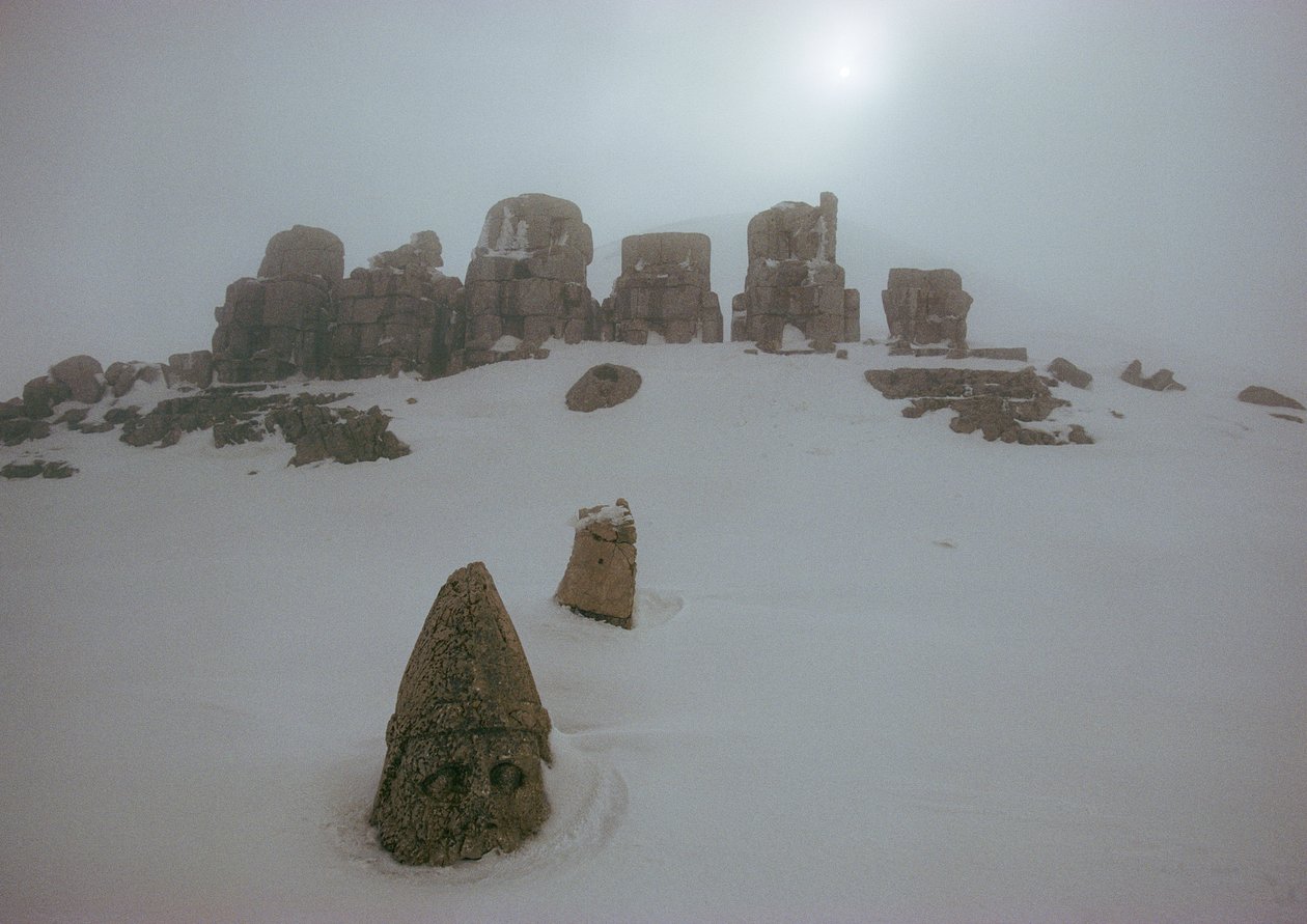 Estatua de un dios sobre un manto de nieve en Nemrud Dagh. Nemrud Dagh, Turquía. de James L Stanfield