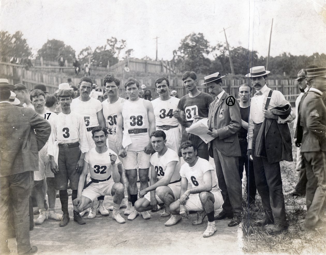 Grupo de atletas griegos y Félix Carbejaldesoto de Cuba posando en la pista de Jessie Tarbox Beals