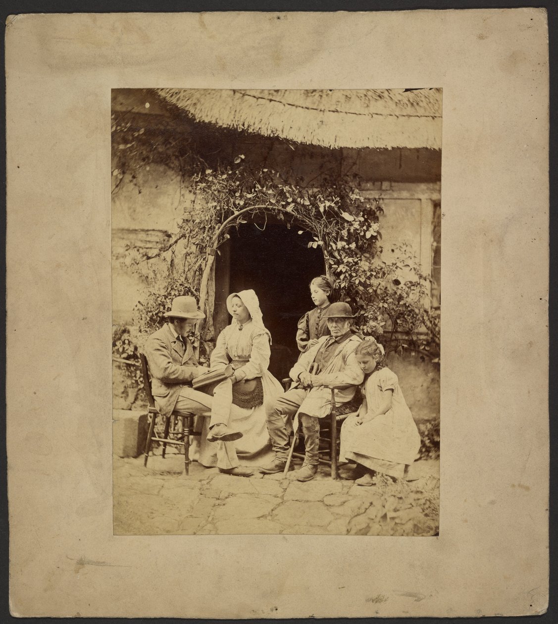 [Grupo sentado fuera de la puerta abierta: dos hombres con sombrero, una mujer con gorro, dos chicas jóvenes - una de pie] de John Whistler