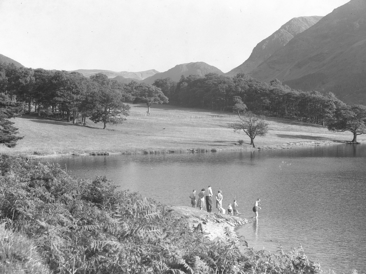Una familia en la orilla del lago pescando y mirando el agua de Joseph Hardman