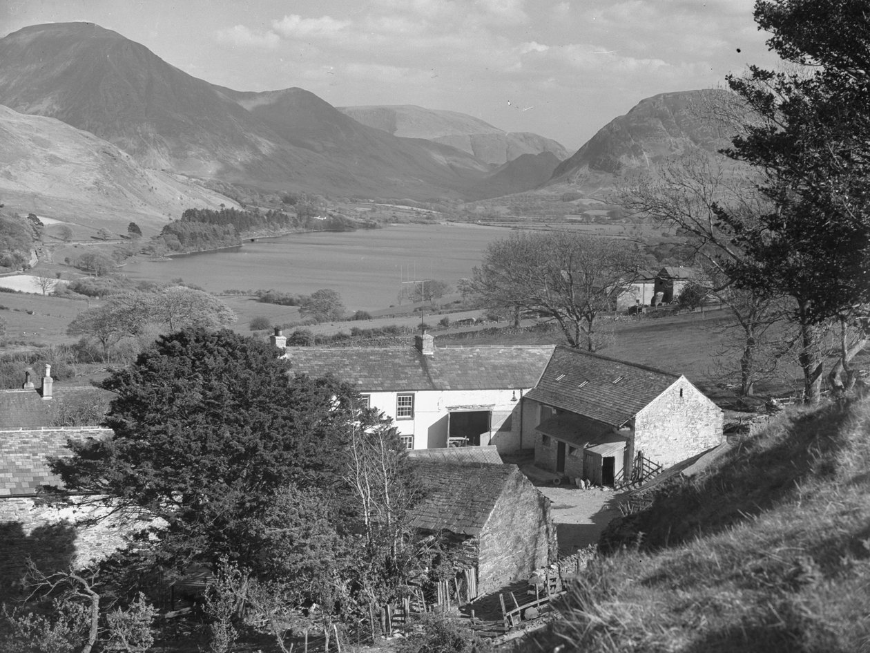 Vista de lo que parece ser una granja en primer plano y un lago y unas colinas al fondo. de Joseph Hardman