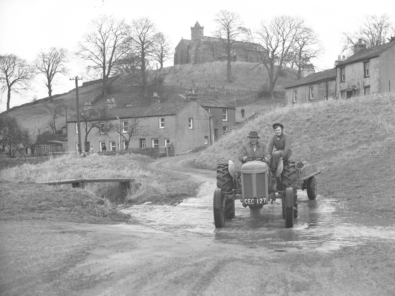 Hombre y mujer conduciendo tractor bajando la carretera por el vado de Crosby Garret de Joseph Hardman