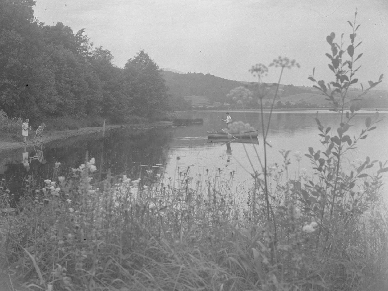 Hombre pescando en una barca en Estwaite Water y dos niñas al borde del agua de Joseph Hardman