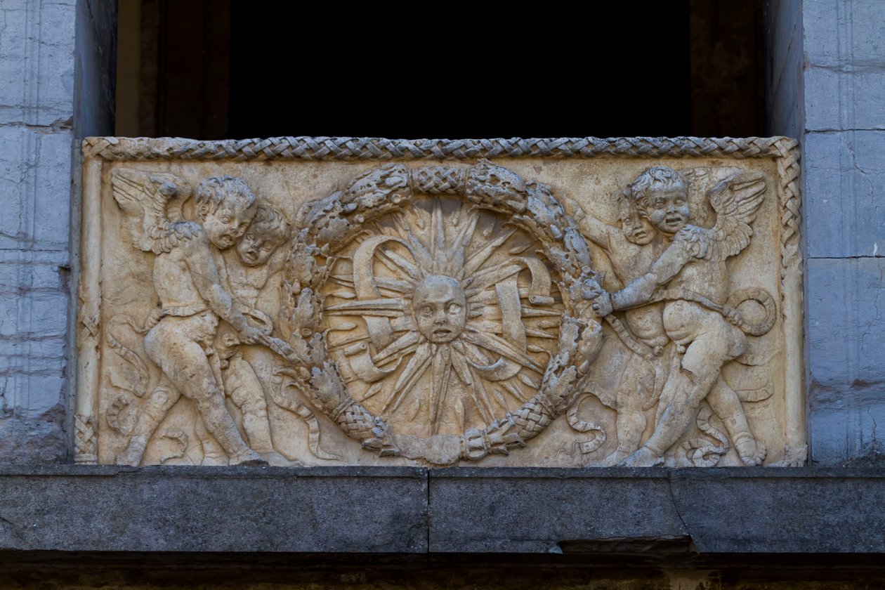 Placa de balaustrada con sol radiante en guirnalda, bajorrelieve en la fachada de la iglesia de San Sebastiano de Leon Battista Alberti
