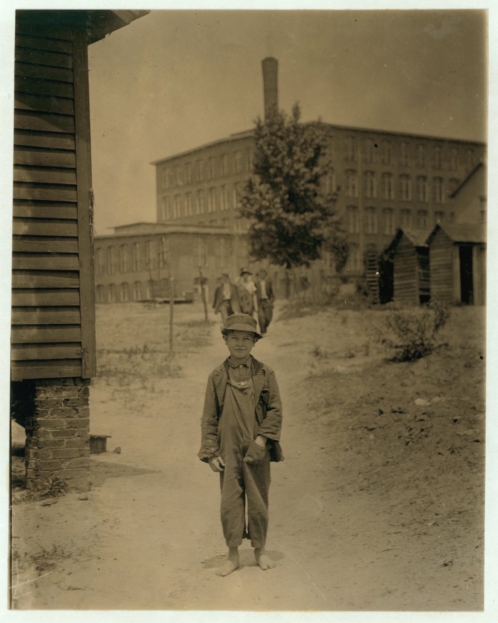 Eddie Norton de 12 años, gana unos 40 centavos al día como barrendero en Saxon Mill, Spartanburg, Carolina del Norte, 1912 de Lewis Wickes Hine
