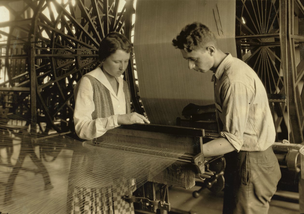 Un niño y una niña trabajan en un telar en la fábrica de seda Cheney Silk Mills en South Manchester, Connecticut. de Lewis Wickes Hine