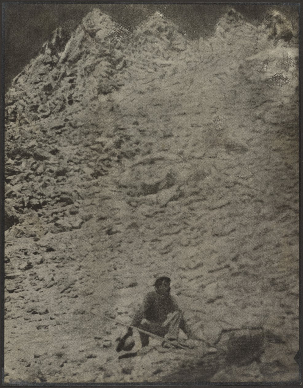 [Hombre agachado en un paisaje rocoso] de Louis Fleckenstein