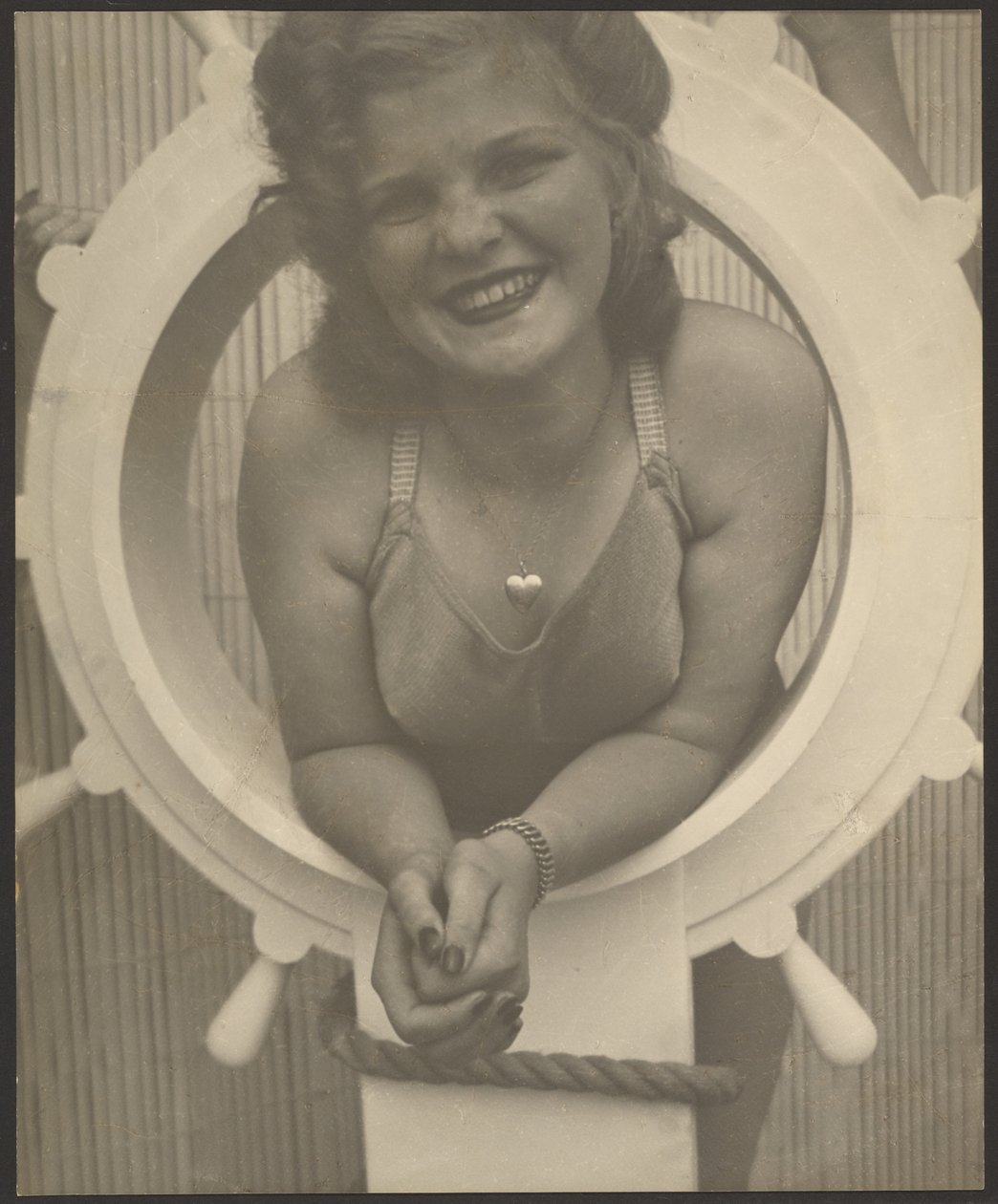 [Mujer posando junto al timón de un barco] de Louis Fleckenstein