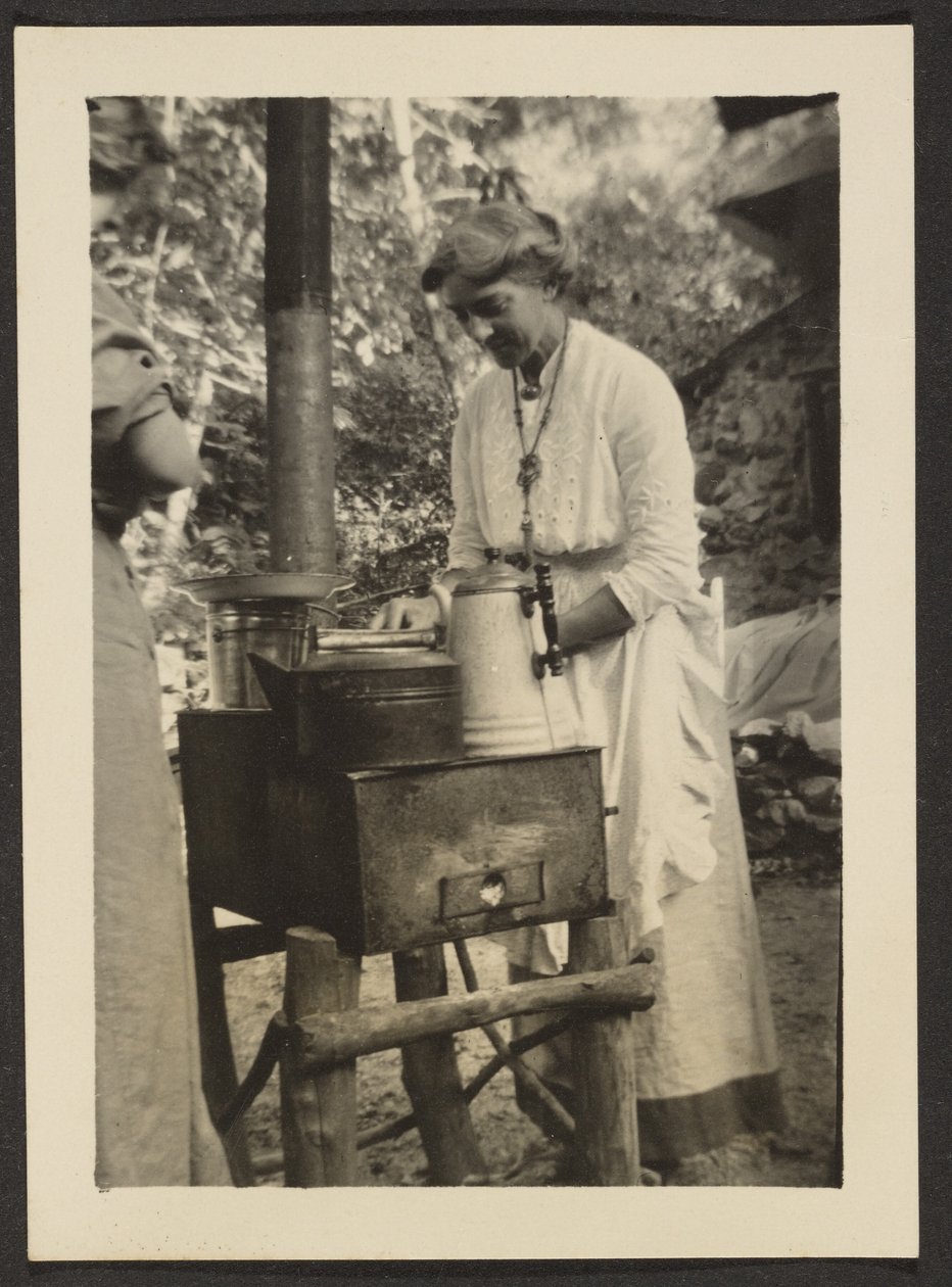 Mujer usando una cocina al aire libre de Louis Fleckenstein