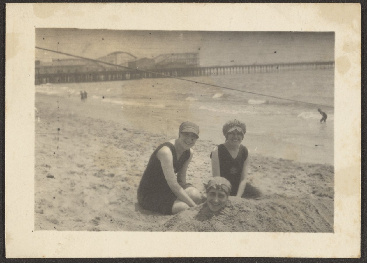 [Mujeres en la playa enterrando a una amiga en la arena] de Louis Fleckenstein