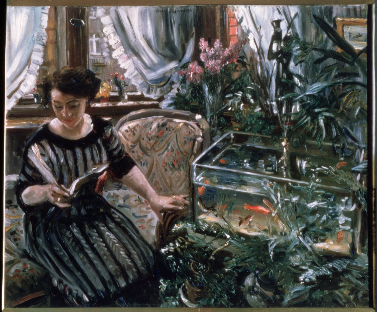 Una mujer leyendo cerca de un tanque de peces dorados de Lovis Corinth