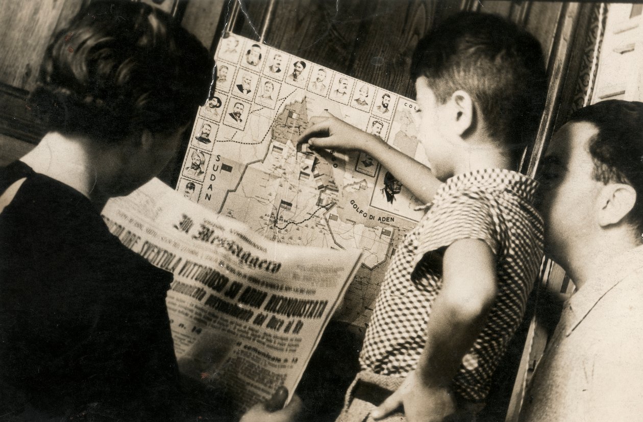 Una mujer lee la portada de The Messenger con el título "La tricolor ondea victoriosa de Adwa recapturada". de Luigi Leoni