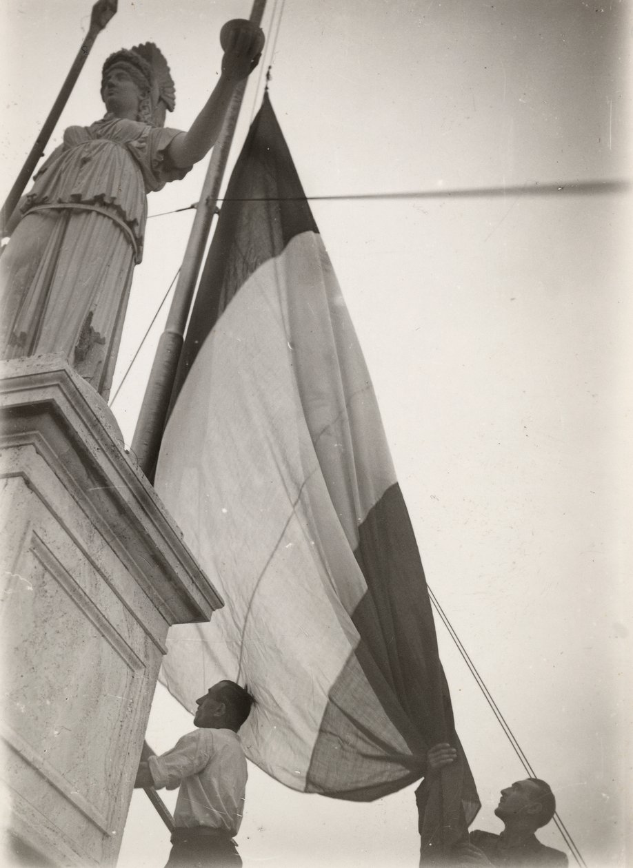 Bandera italiana izada junto a una estatua de Luigi Leoni