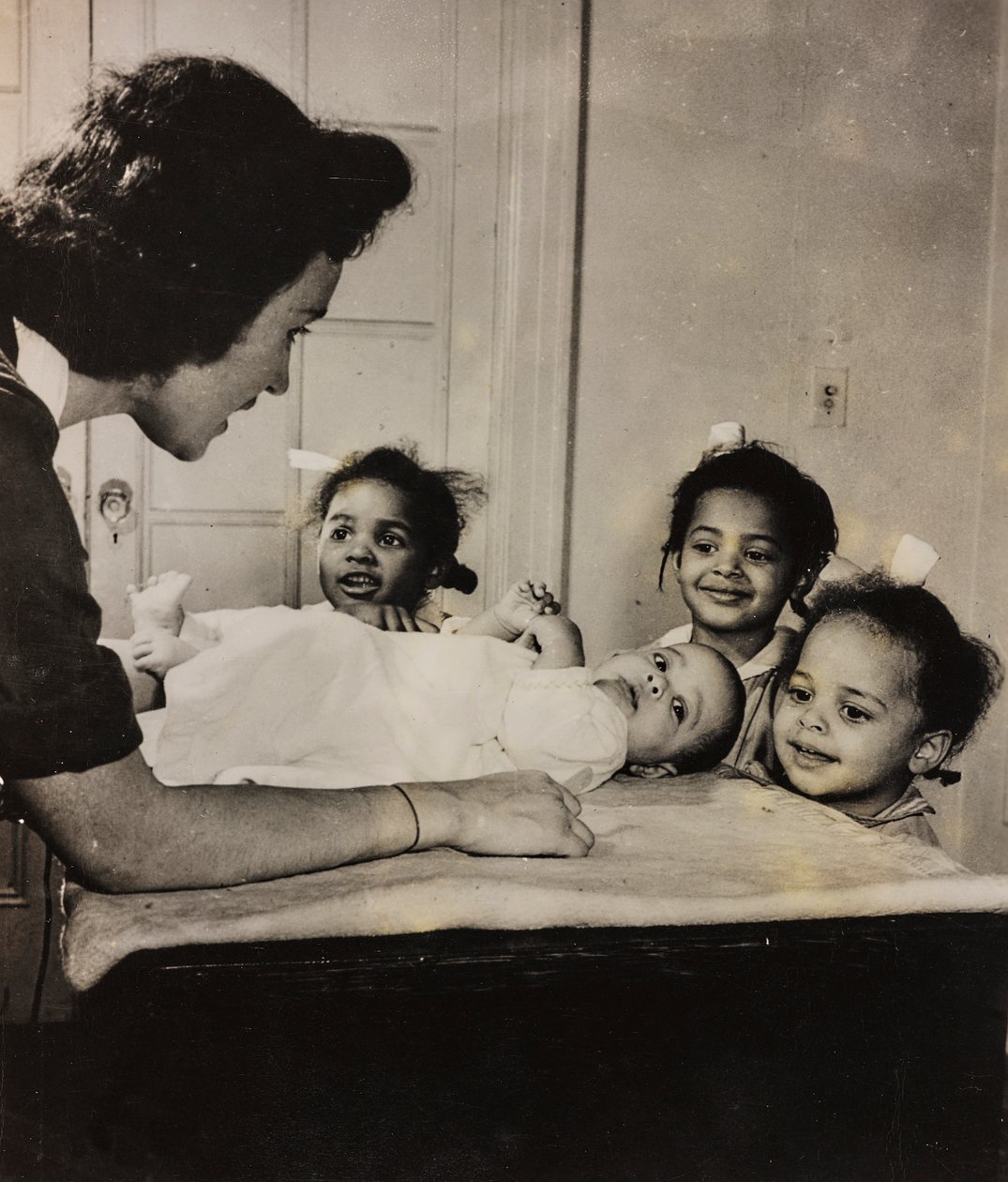 La enfermera Henry Street asiste a tres niñas afroamericanas en Harlem, Nueva York de Luigi Leoni
