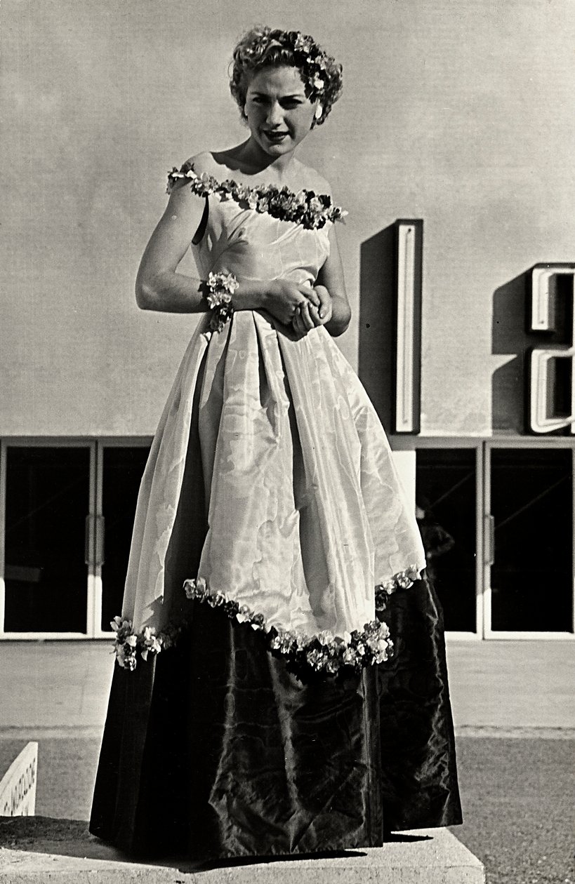 Modelo en vestido de gala creado por la casa de alta costura "Graldi". El artículo se caracteriza por un escote bajo y una falda completa decorada con apliques florales. de Luis Bogino