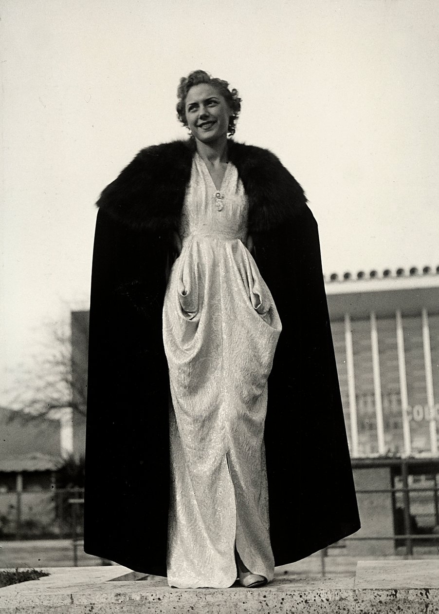 Modelo en vestido de noche, una creación de la casa de alta costura "Graldi". El artículo se complementa con una capa con ribete de piel. de Luis Bogino