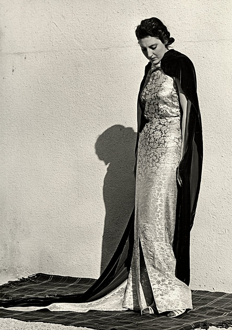 Modelo en vestido de noche creado por la casa de alta costura italiana "Dragoni". El artículo se complementa con un largo manto de terciopelo. de Luis Bogino