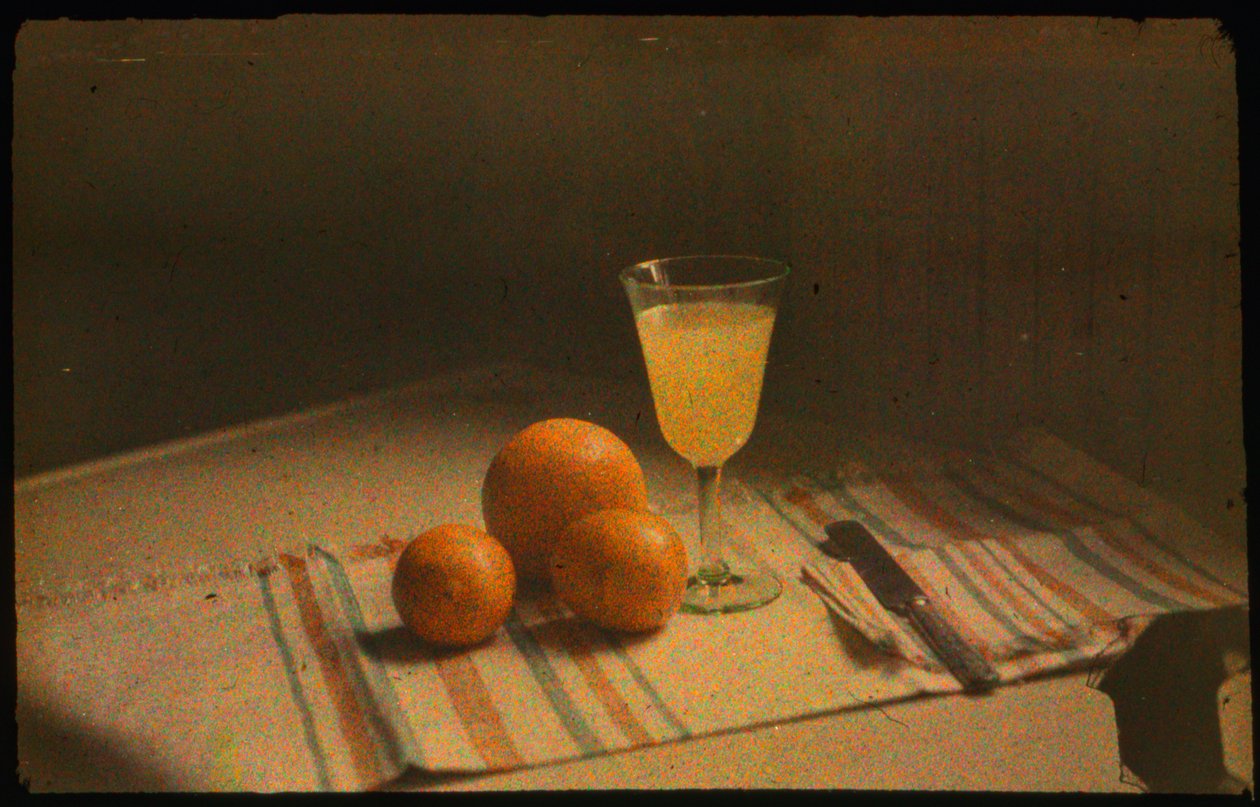 Fotografía en color de un bodegón de naranjas frescas y un vaso de zumo de naranja tomada con... de Luis Marden