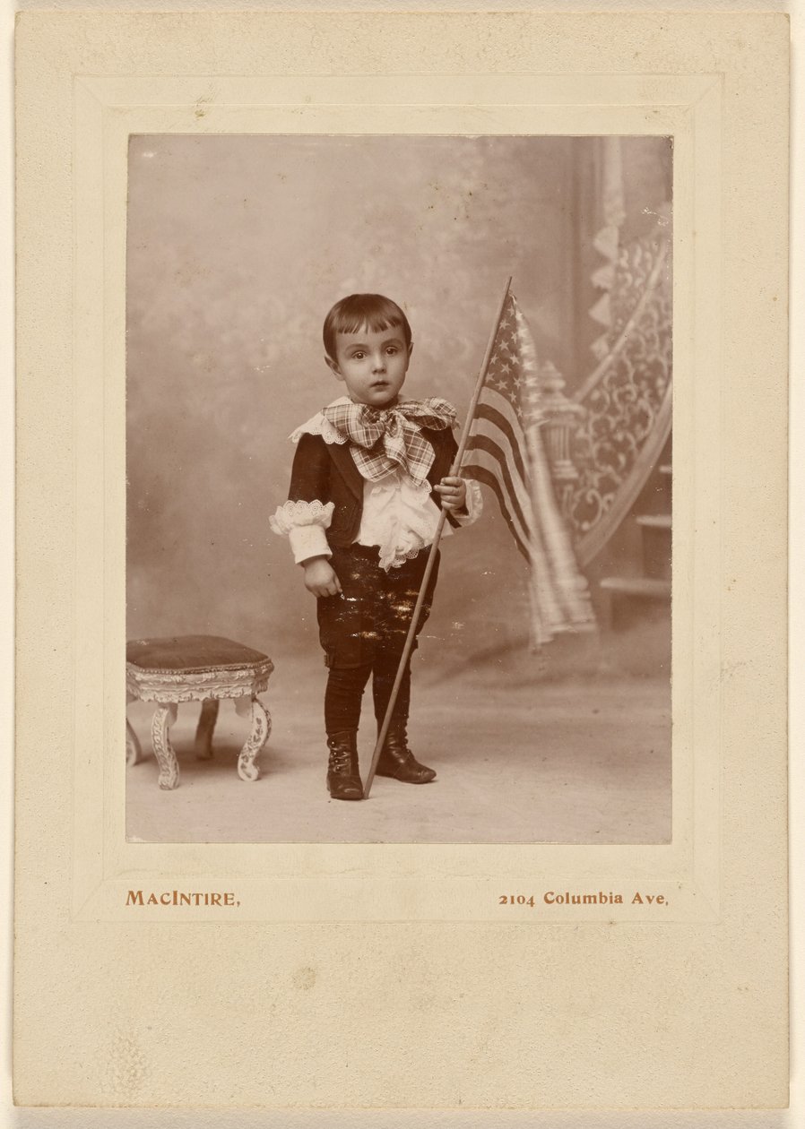 [Niño de pie, sosteniendo una bandera americana] de MacIntire
