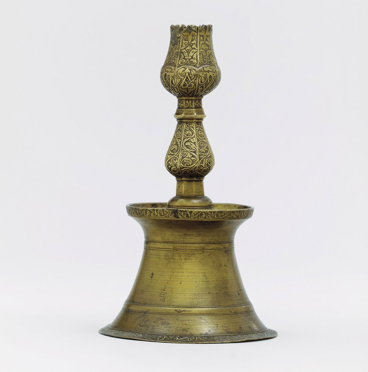 Un candelabro de latón otomano, el cuello con decoración incisa de arabescos que se eleva en forma de tulipán de Ottoman School